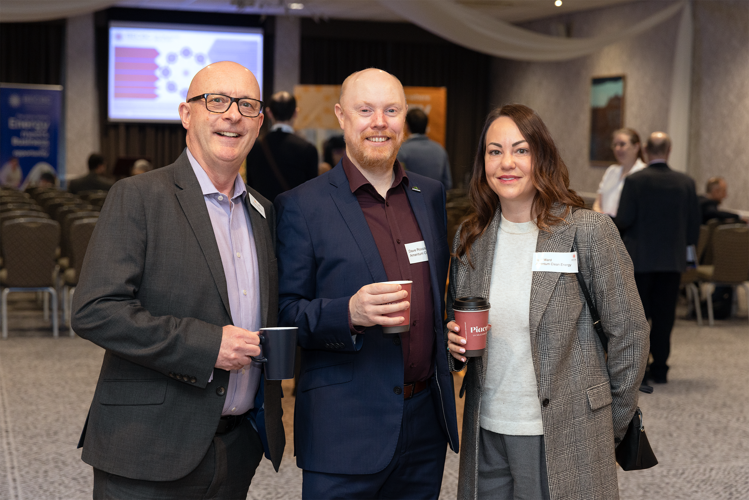 Three attendees networking at a business event in Cumbria, photographed by a professional event photographer.